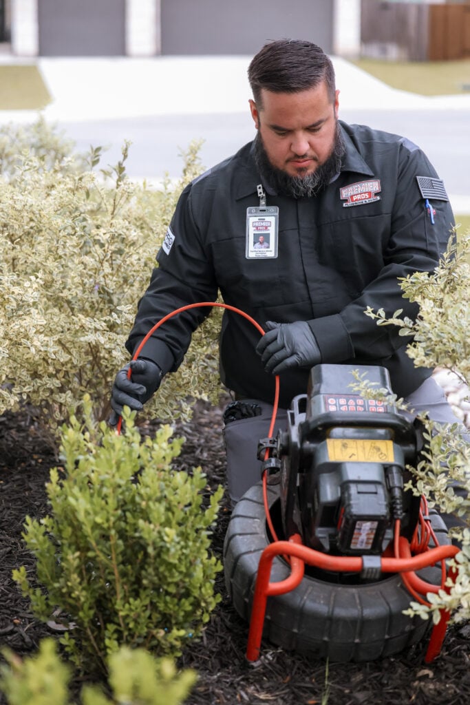 Premier Pros plumber using advanced leak detection equipment on a water pipe in a San Antonio home