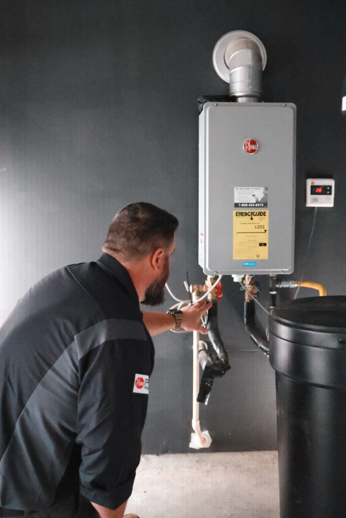 Premier Pros Plumbing & HVAC technician installing a new water heater in a San Antonio home, demonstrating expert water heater installation and replacement services.