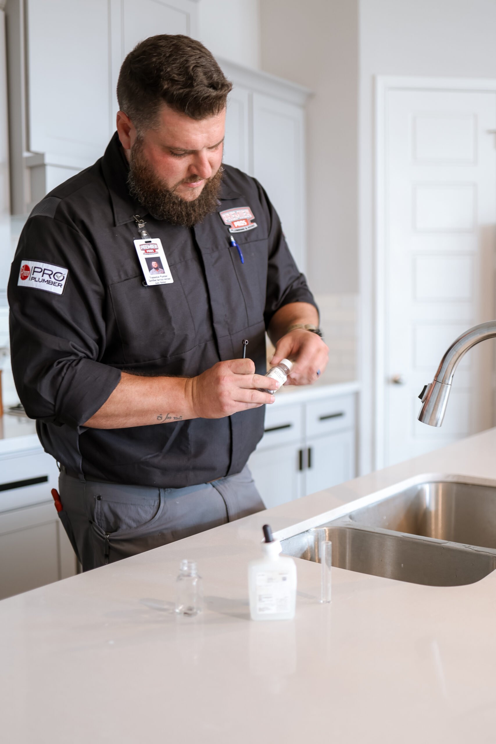 Premier Pros plumber performing a water quality test at a kitchen sink in a San Antonio home