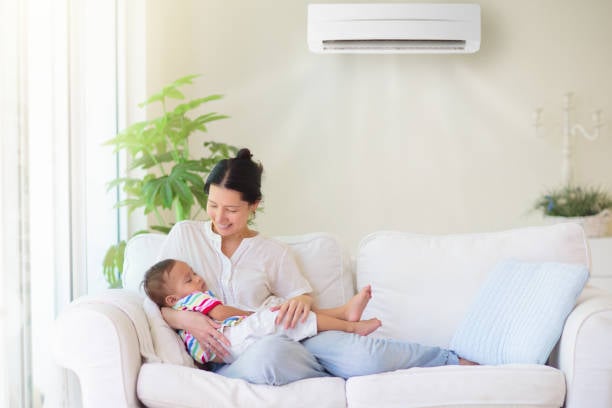 A happy family relaxing in their cool, comfortable living room thanks to their new AC from Premier Pros.